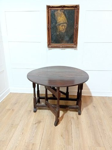 A seventeenth-century dark oak gateleg table with folded leaves, turned legs, and a stretcher base. View XII