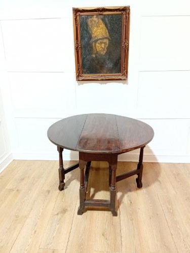 A seventeenth-century dark oak gateleg table with folded leaves, turned legs, and a stretcher base. View XIII