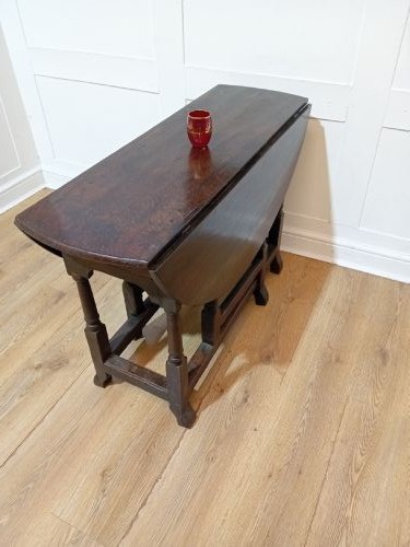 A seventeenth-century dark oak gateleg table with folded leaves, turned legs, and a stretcher base. View VII