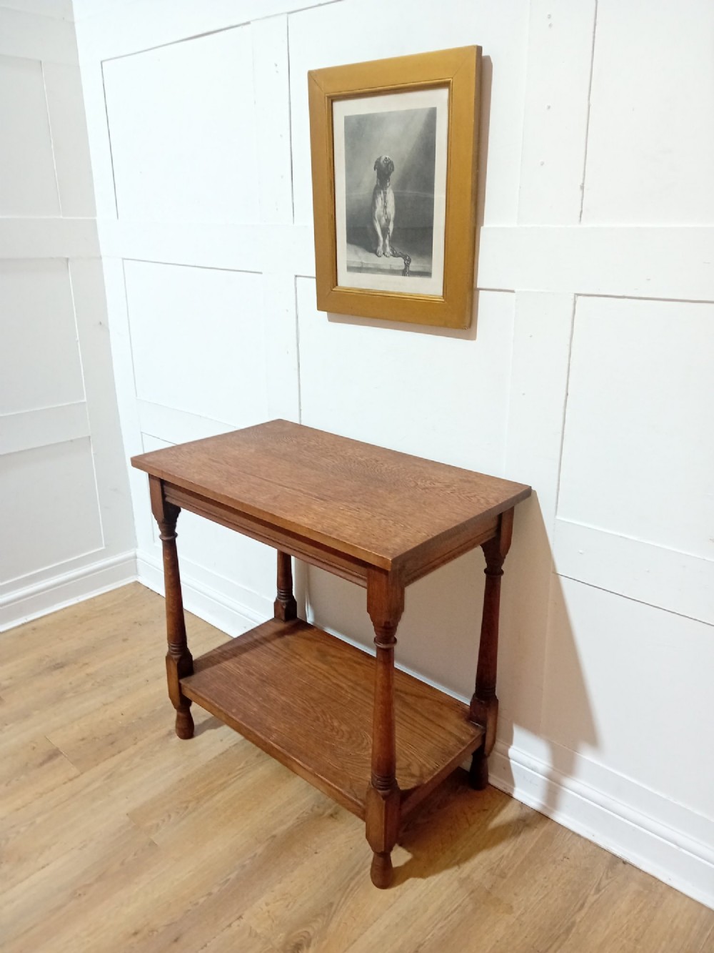 A late Victorian medium brown oak side table featuring a rectangular top, an open lower shelf, and four slender turned wooden legs. View II