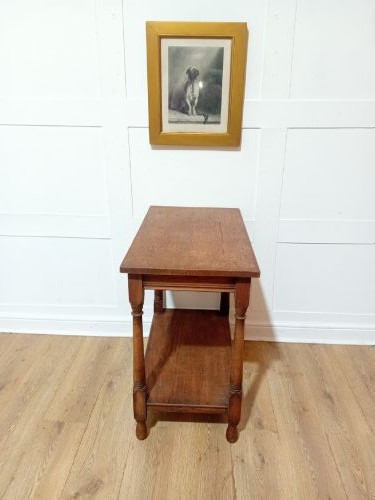 A late Victorian medium brown oak side table featuring a rectangular top, an open lower shelf, and four slender turned wooden legs. View X