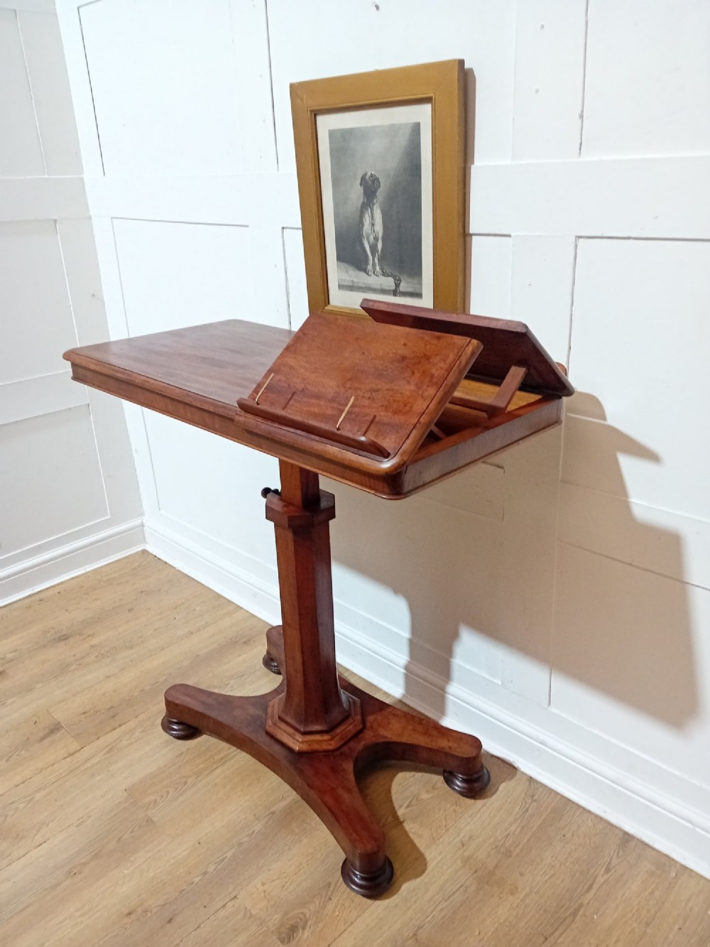 An antique Victorian mahogany reading table featuring a dual tilting ratcheted top on a turned pedestal column and quadripartite base. View IX