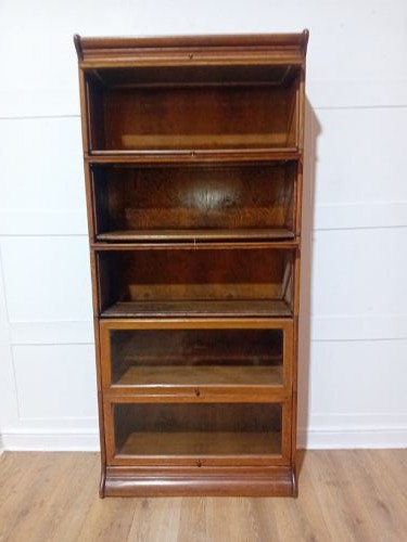 An Edwardian golden oak five-tier sectional barrister bookcase featuring glazed lifting doors with brass handles and a moulded top cornice. View IX