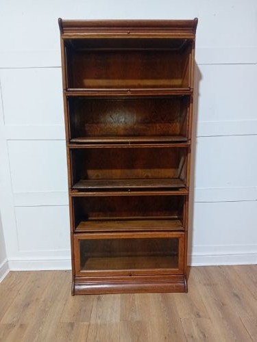 An Edwardian golden oak five-tier sectional barrister bookcase featuring glazed lifting doors with brass handles and a moulded top cornice. View X