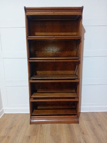 An Edwardian golden oak five-tier sectional barrister bookcase featuring glazed lifting doors with brass handles and a moulded top cornice. View XI