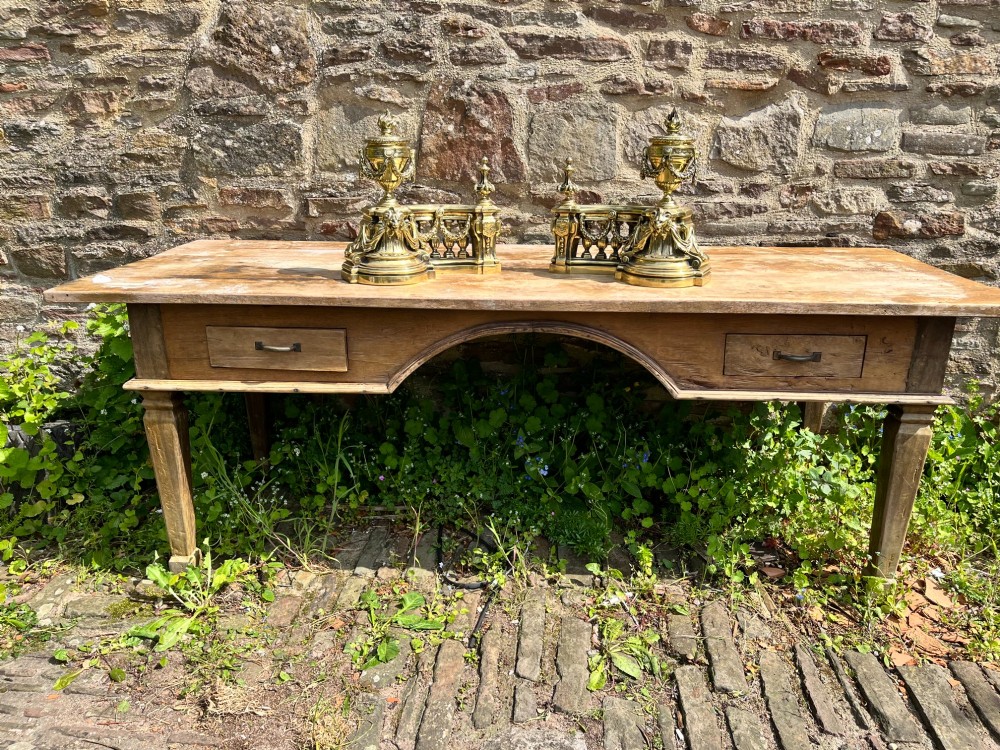 A pair of ornate brass fire dogs in the Louis XVI style, featuring draped flaming urns atop balustraded bases. View III
