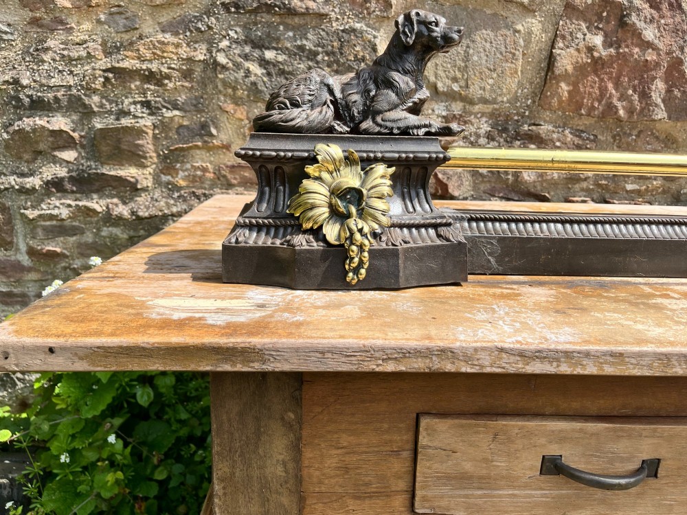 A French cast iron and brass fireplace fender featuring recumbent dog sculptures on rectangular plinths joined by a horizontal central rail. View IV