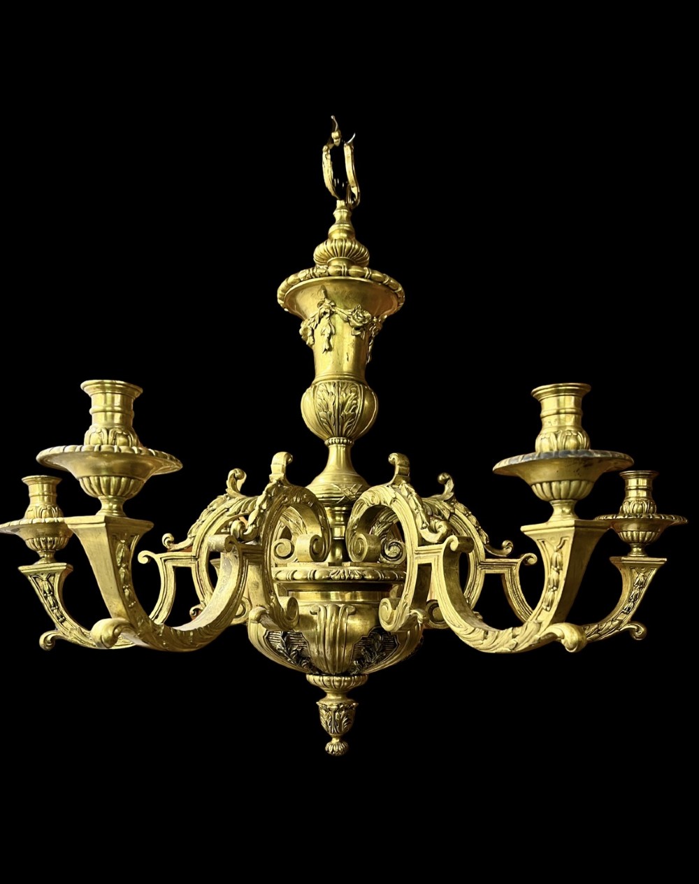 A Georgian style cast brass chandelier featuring a central urn-shaped column, ornate scroll arms, and candle-style sconces with acanthus leaf decoration.
