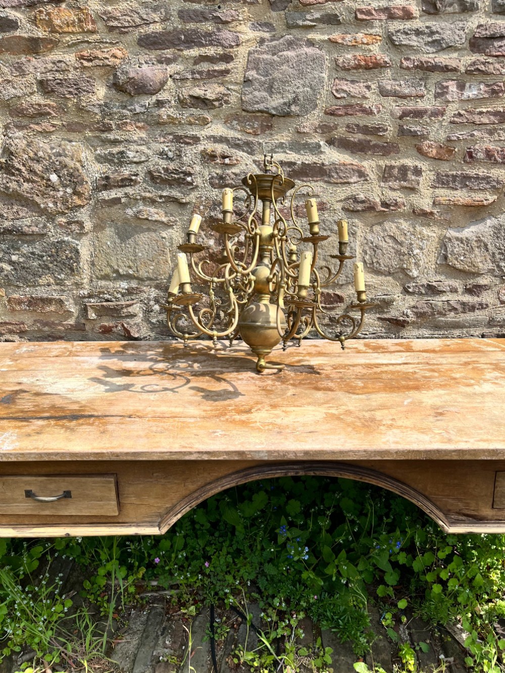 An antique brass gasolier chandelier featuring multiple scrolled arms, faux candle light sockets, and a central bulbous stem. View IV