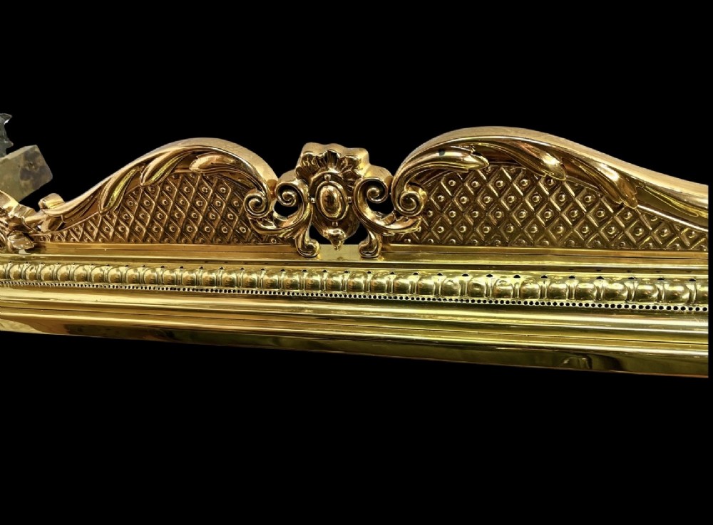 An ornate brass and bronze fireplace fender featuring Rococo scrollwork, lattice panels, and female figural end ornaments. View III