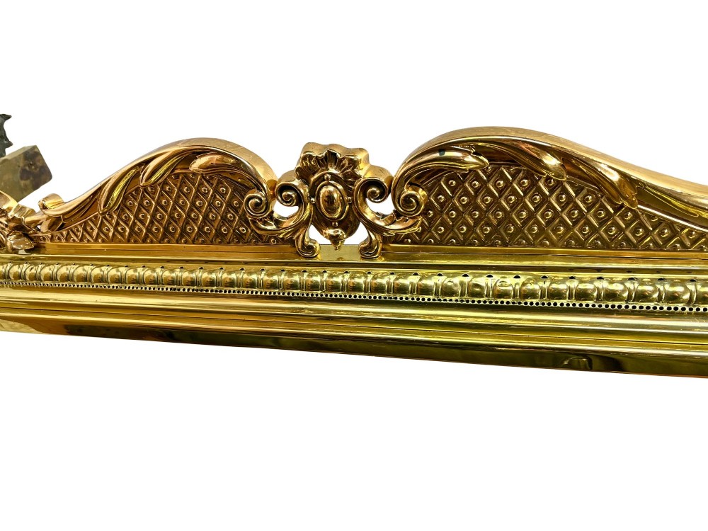 An ornate brass and bronze fireplace fender featuring Rococo scrollwork, lattice panels, and female figural end ornaments. View VI