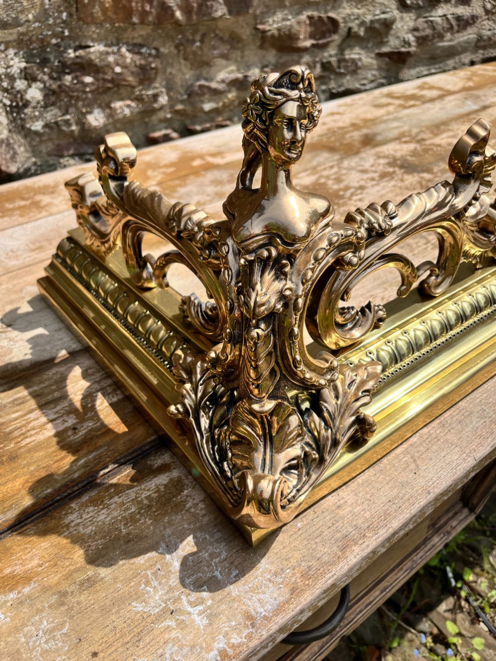 An ornate brass and bronze fireplace fender featuring Rococo scrollwork, lattice panels, and female figural end ornaments. View VIII