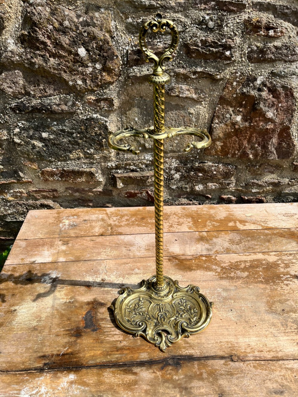 An ornate brass fire iron tidy featuring a detailed scrollwork base, a twisted central column, dual hanging hooks, and an ornamental top handle. View IV