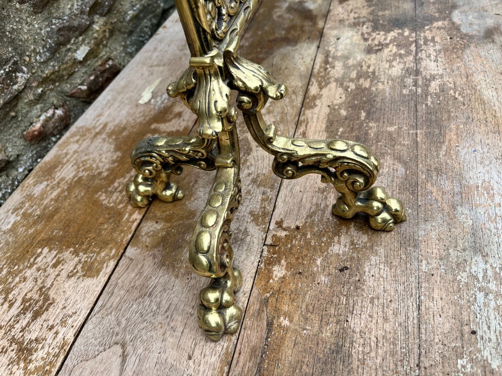 An ornate cast brass fire screen featuring cherub cresting, foliate side scrollwork, fine wire mesh insert, and four decorative feet. View IV