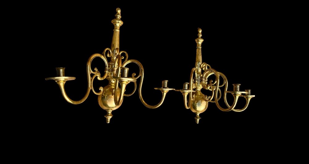 A pair of brass candle wall sconces featuring multi-branch scrolling arms, candle cups with drip pans, and turned central spindles. View II