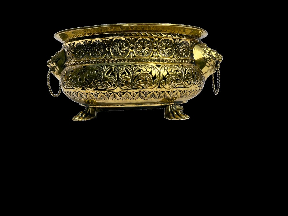 A round antique Dutch brass jardiniere featuring intricate repousse foliate patterning, dual lion-head ring handles, and claw feet. View II