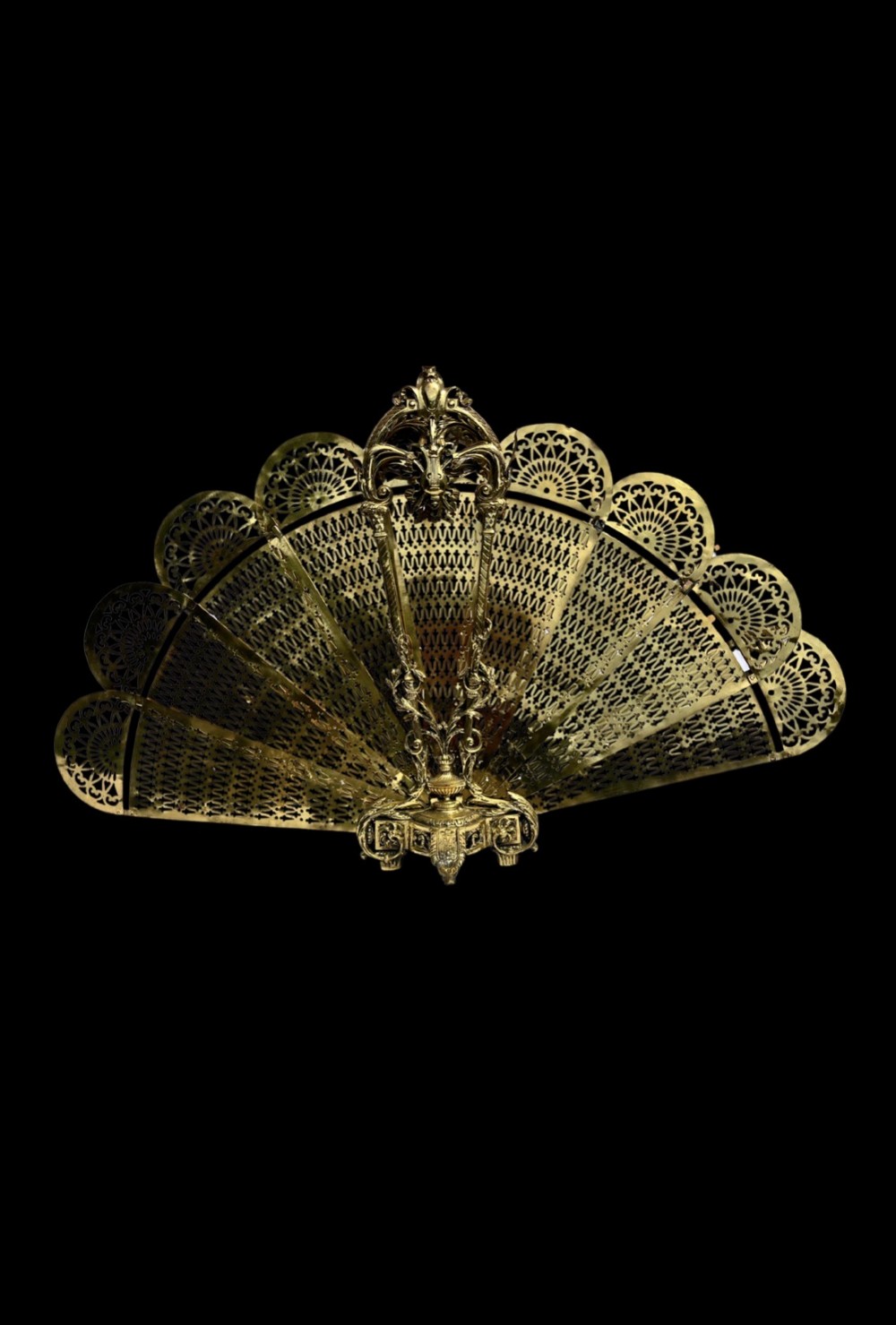 An antique folding brass fan fire screen featuring pierced filigree leaves and an ornate cast central handle. View III