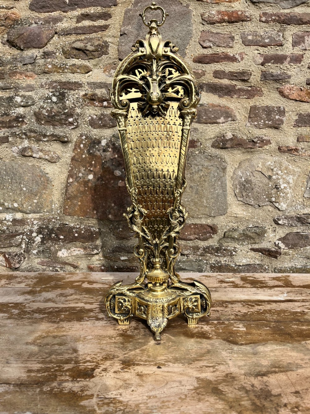 An antique folding brass fan fire screen featuring pierced filigree leaves and an ornate cast central handle. View VIII