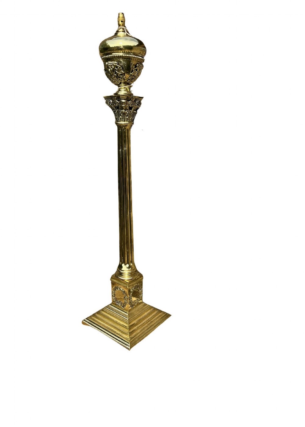 An antique polished brass standard floor lamp featuring a fluted column, classical Corinthian capital, urn motif, and stepped square base.