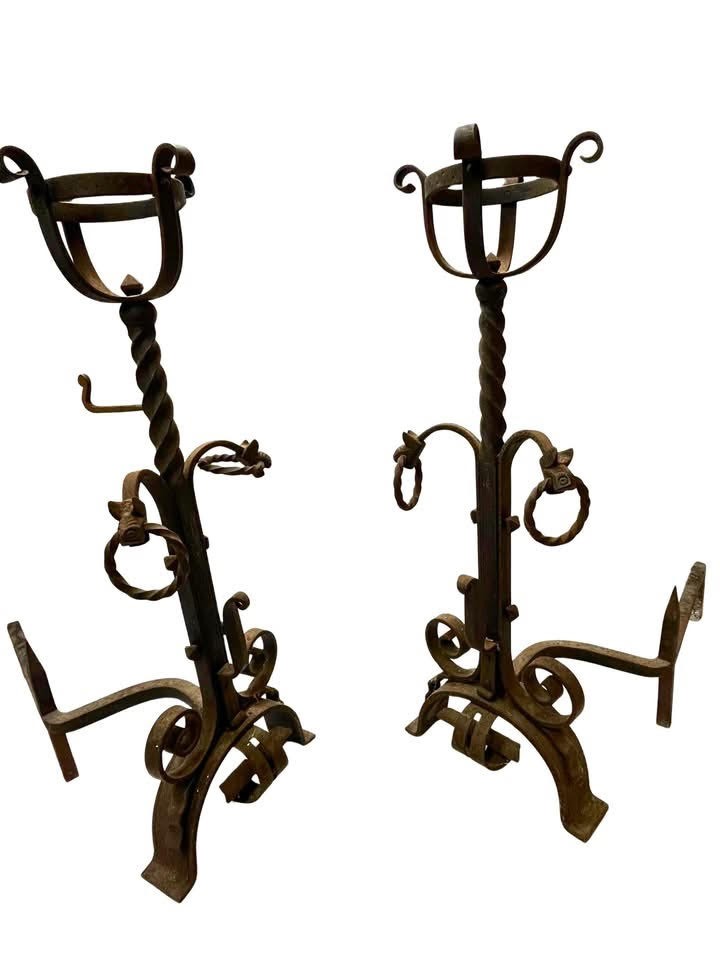 Pair of antique hand-forged wrought iron firedogs featuring barley twist stems, cresset basket tops, scrolled feet, and rear log rests.