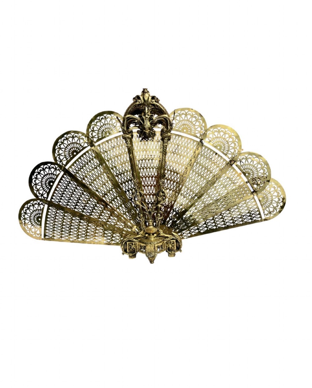 An antique folding brass fan fire screen featuring pierced filigree leaves and an ornate cast central handle.