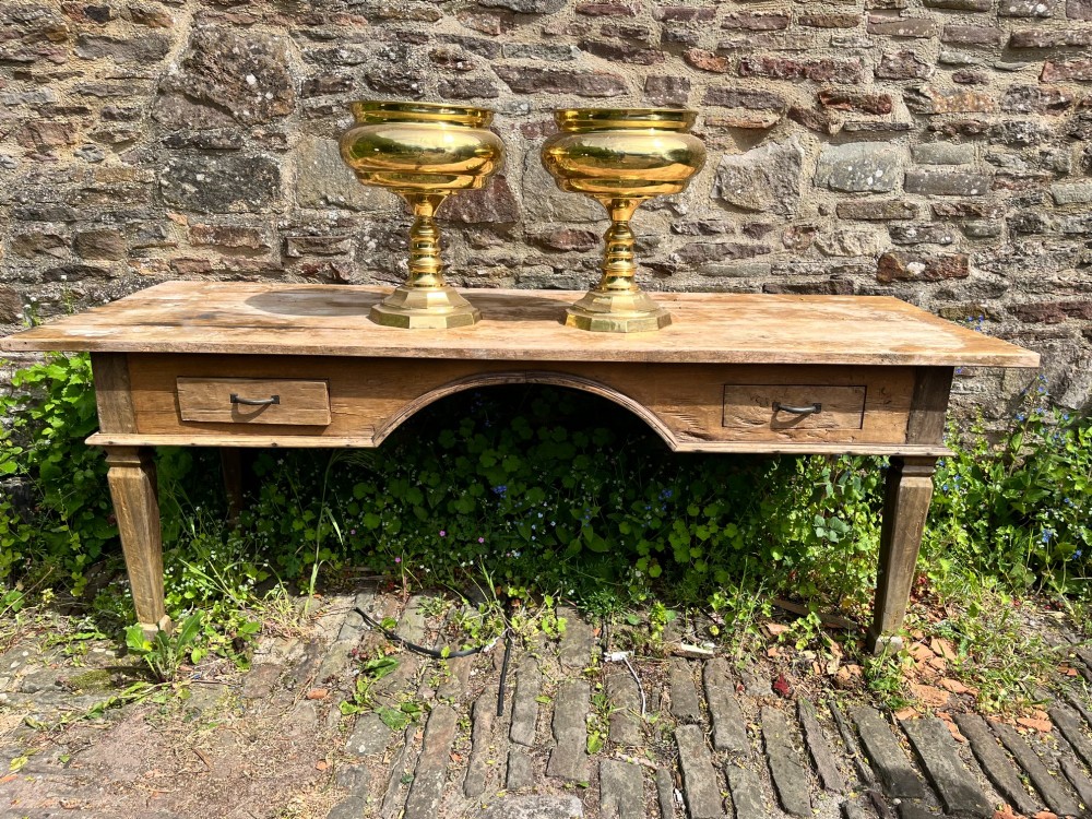 A pair of polished brass goblets featuring wide rounded bowls, turned baluster stems, and octagonal bases. View III