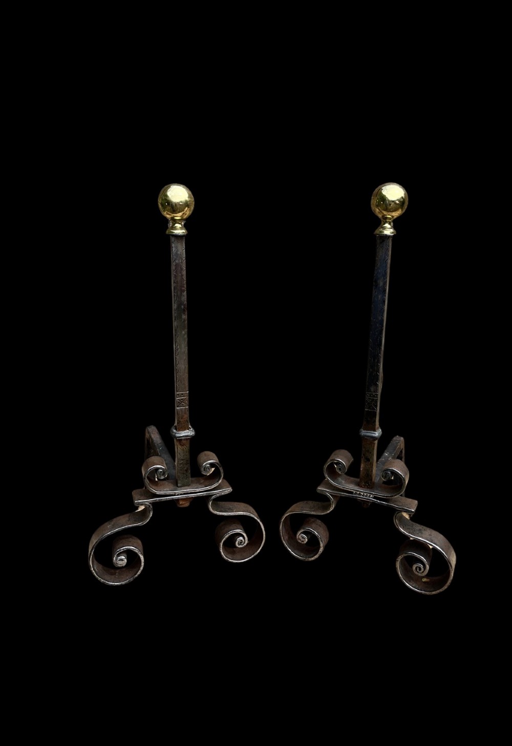 A pair of French wrought iron fire dogs featuring scroll legs and spherical brass finials atop vertical stems. View II