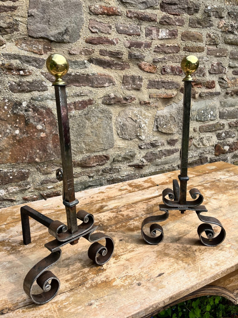 A pair of French wrought iron fire dogs featuring scroll legs and spherical brass finials atop vertical stems. View III