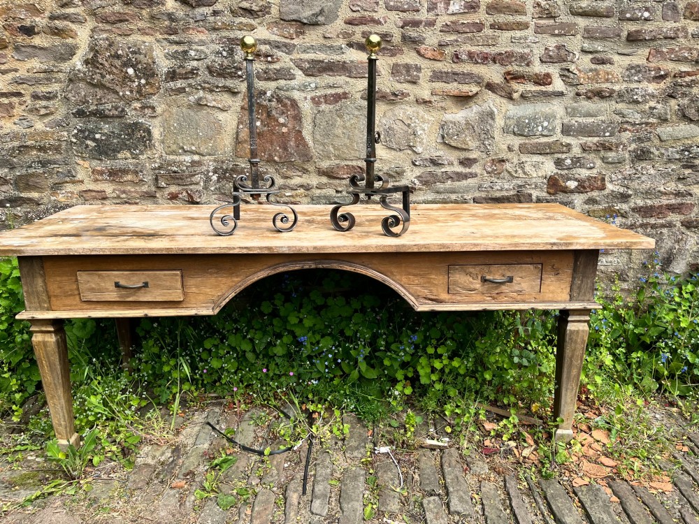 A pair of French wrought iron fire dogs featuring scroll legs and spherical brass finials atop vertical stems. View IV