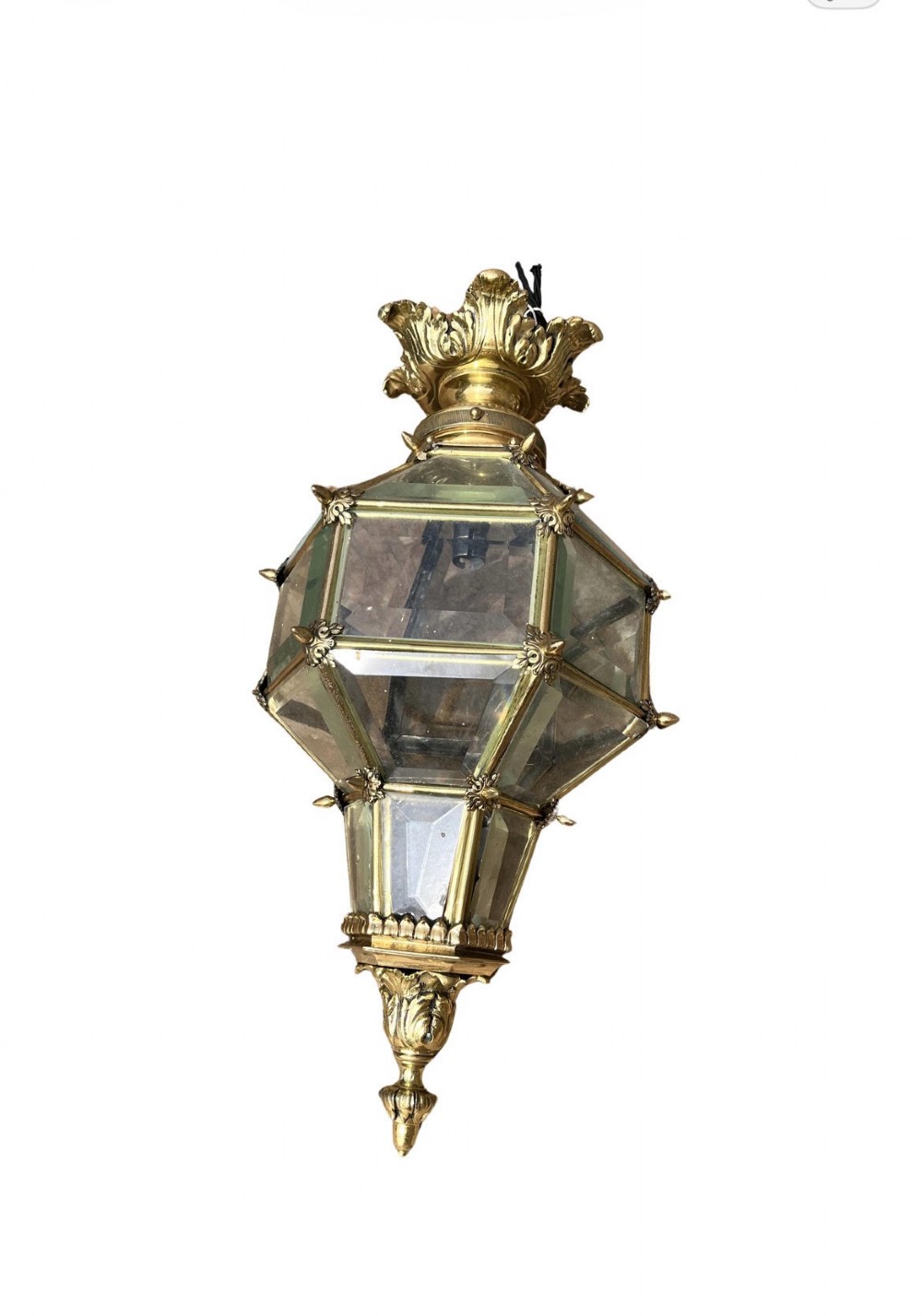 An ornate Versailles style French brass hanging lantern featuring bevelled glass panels, cast metal mouldings, and a leaf motif crown.