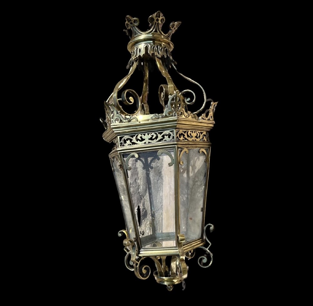 A large ornate brass hanging hall lantern featuring glazed glass panels, a coronet crown top, pierced metal fretwork, and scrollwork accents. View II