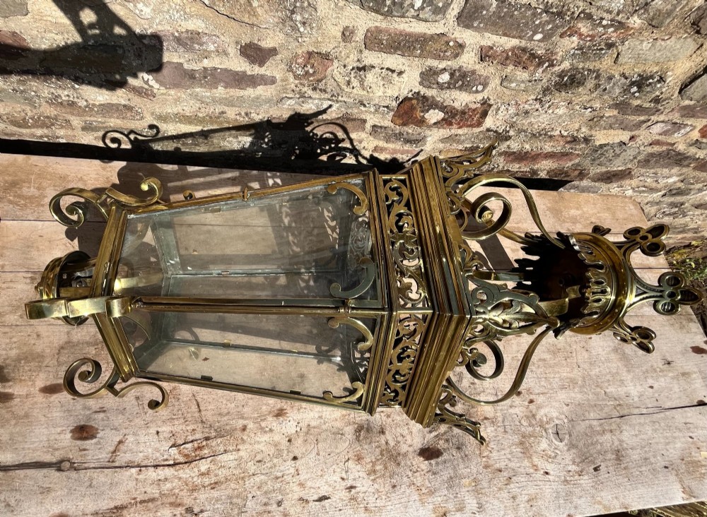 A large ornate brass hanging hall lantern featuring glazed glass panels, a coronet crown top, pierced metal fretwork, and scrollwork accents. View IV