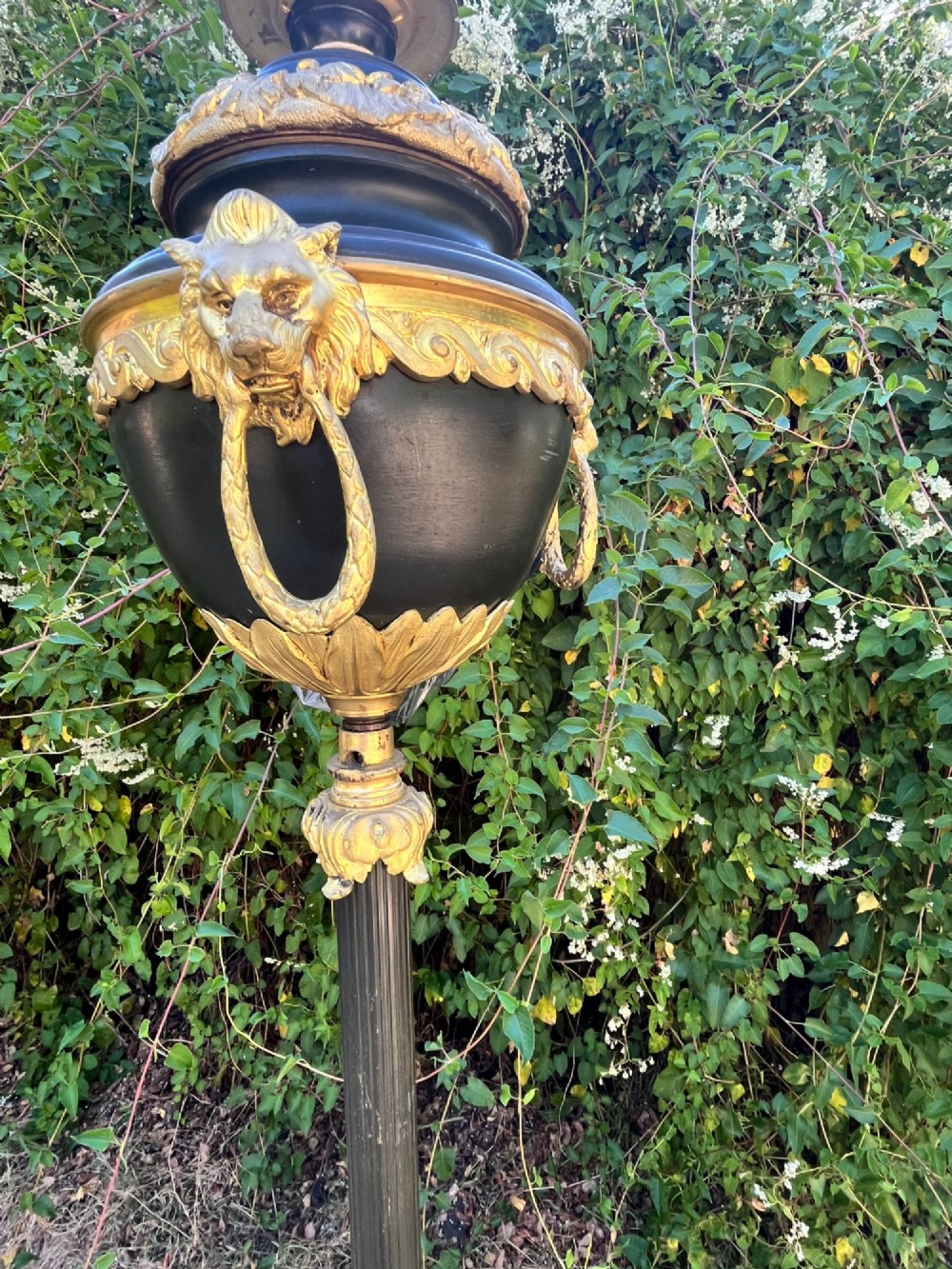 A Victorian gilt bronze and black patinated metal standard floor lamp with a lion mask urn top section, fluted shaft, and tripod paw feet. View V