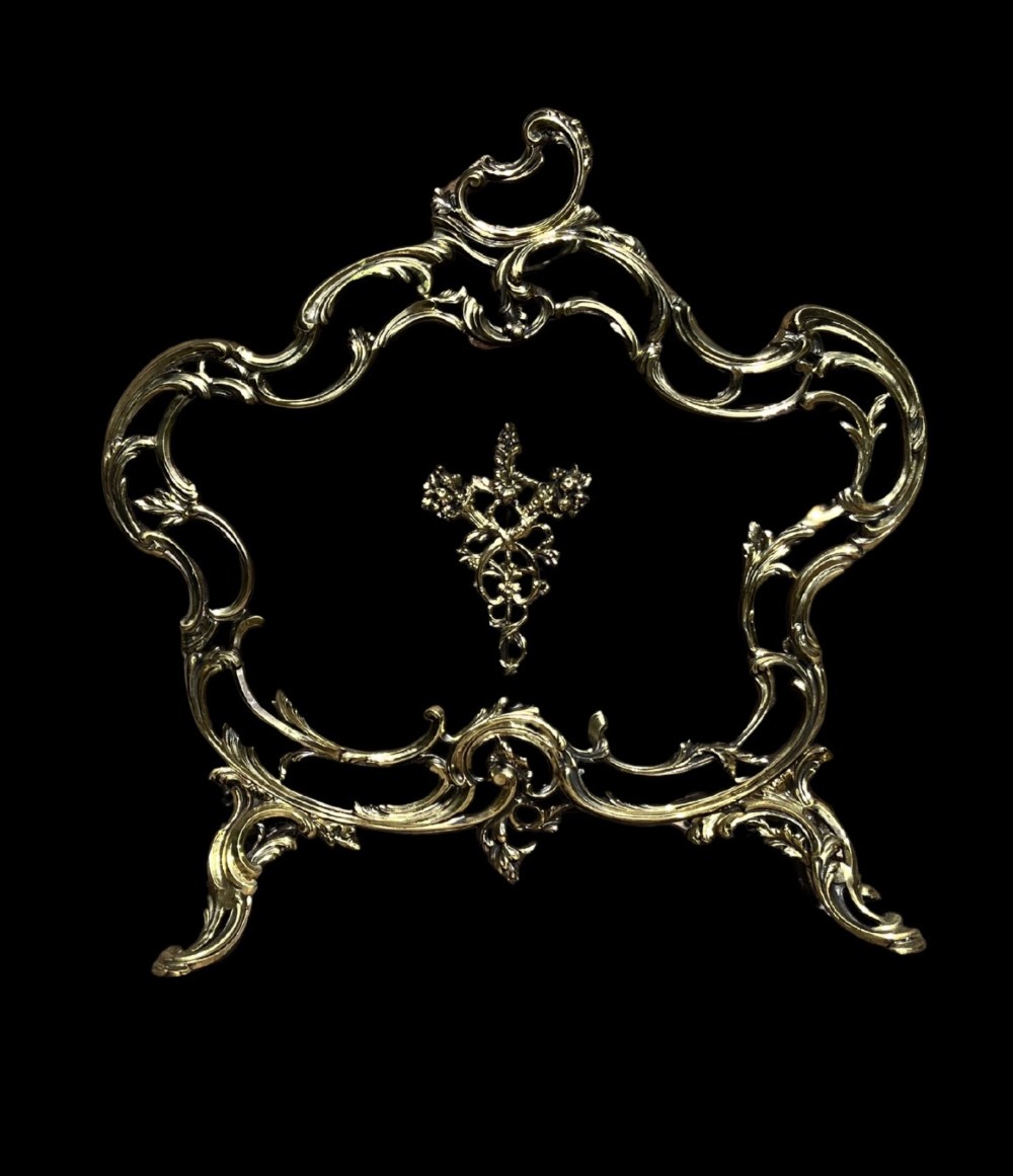 An ornate French Rococo style gilt bronze fire screen featuring elaborate scrolled rocaille framework, cabriole legs, and a central decorative motif. View II