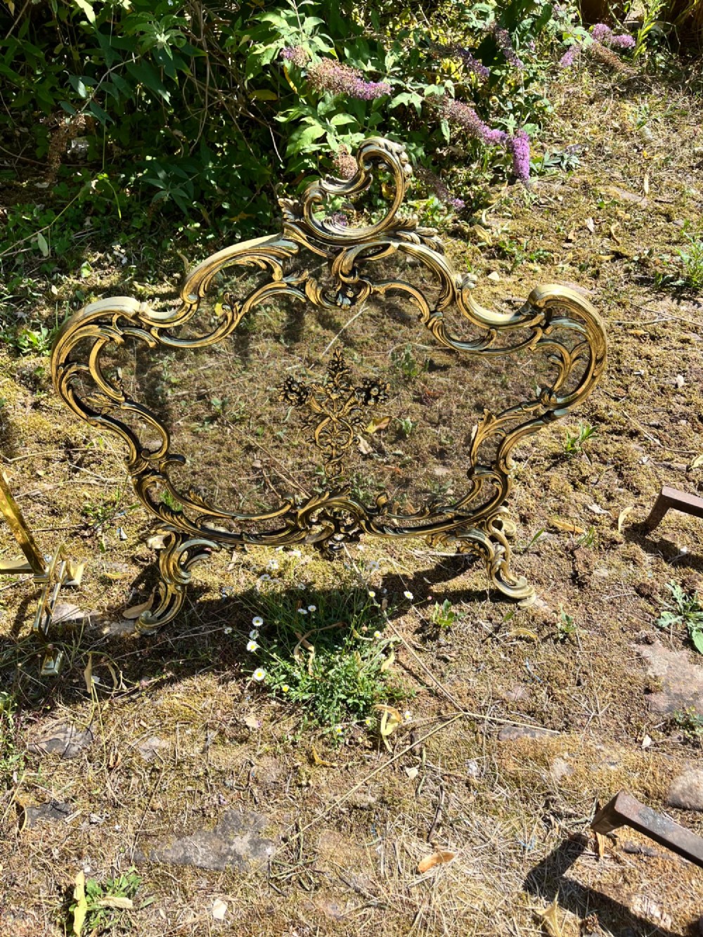 An ornate French Rococo style gilt bronze fire screen featuring elaborate scrolled rocaille framework, cabriole legs, and a central decorative motif. View VI