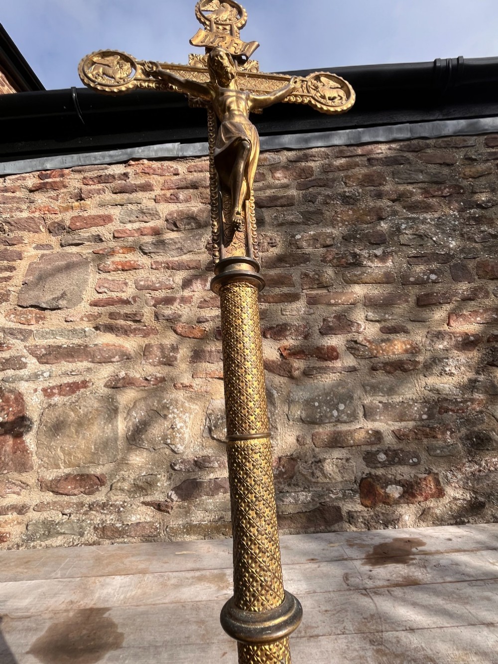A cast gilt brass processional crucifix featuring the figure of Christ surrounded by circular medallions depicting the Evangelist symbols. View V