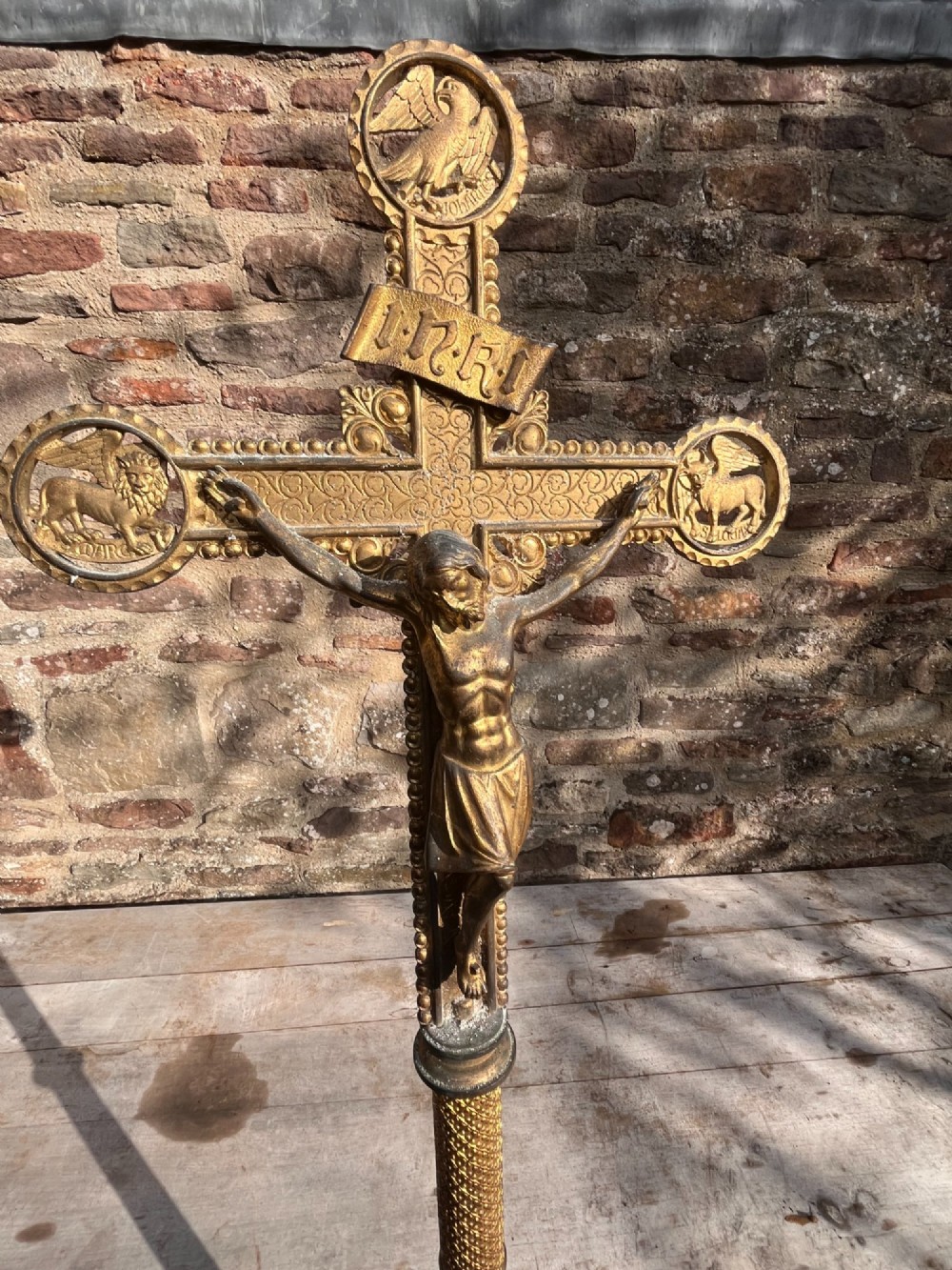 A cast gilt brass processional crucifix featuring the figure of Christ surrounded by circular medallions depicting the Evangelist symbols. View VI