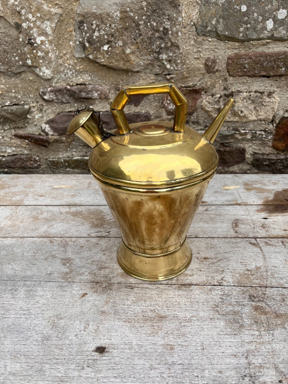 An antique polished brass oil vessel featuring an angular top handle, a long thin pouring spout, and a capped filler spout on a pedestal base. View V