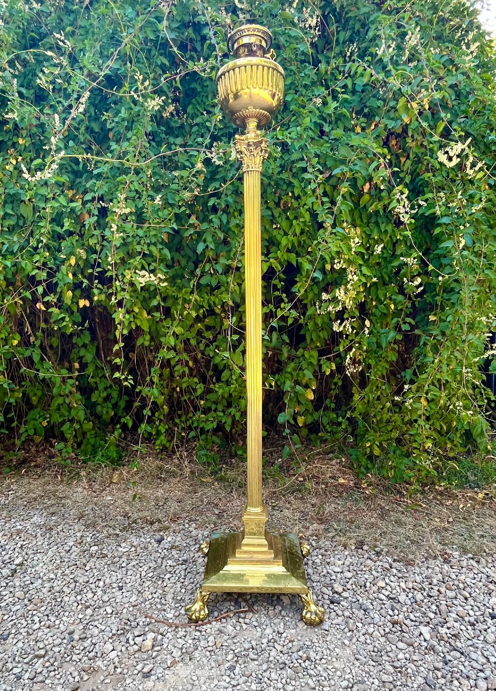 A solid brass floor lamp featuring a fluted Corinthian column stem, an urn-shaped reservoir top, and a stepped square base supported by claw feet. View III