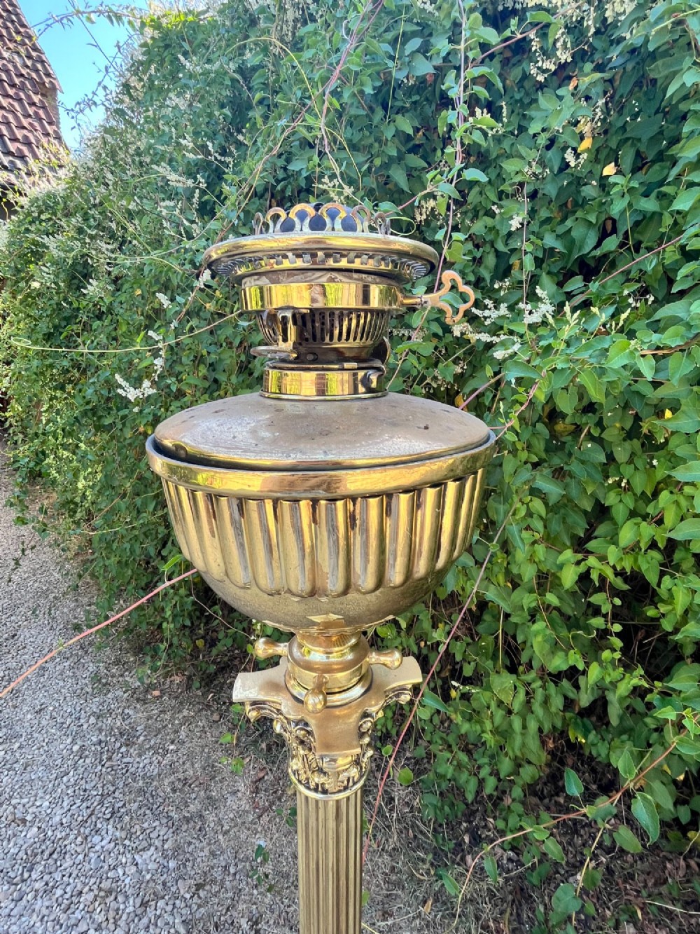 A solid brass floor lamp featuring a fluted Corinthian column stem, an urn-shaped reservoir top, and a stepped square base supported by claw feet. View IV