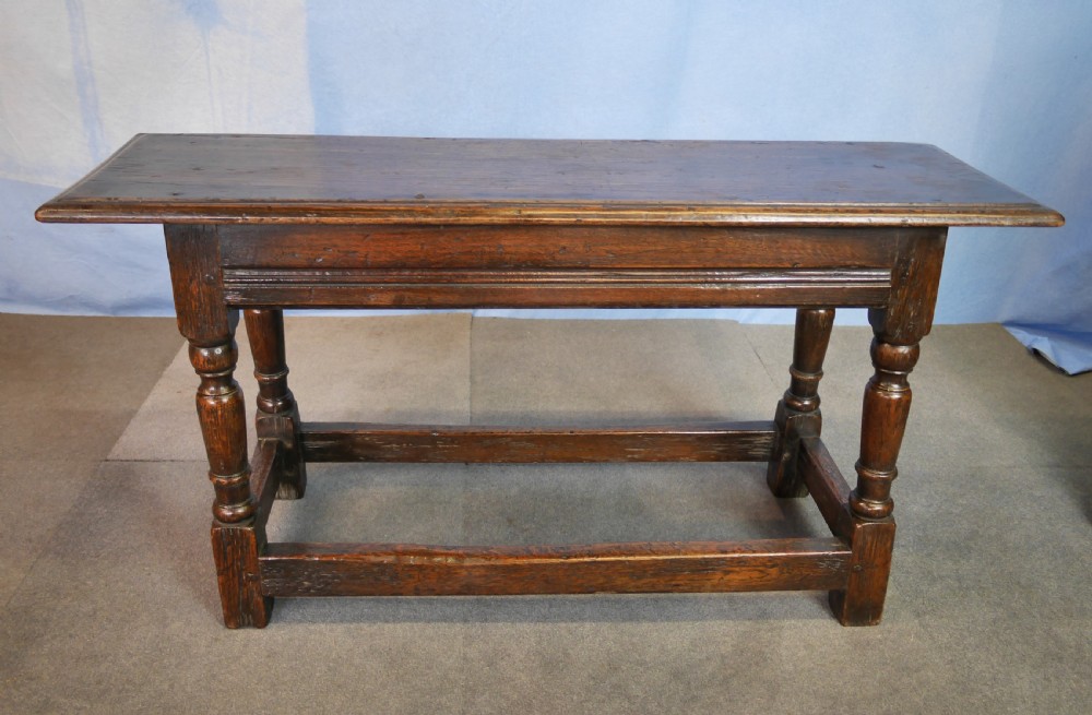 A low rectangular dark oak coffee table featuring baluster-turned legs, block feet, and a surrounding low box stretcher. View VII