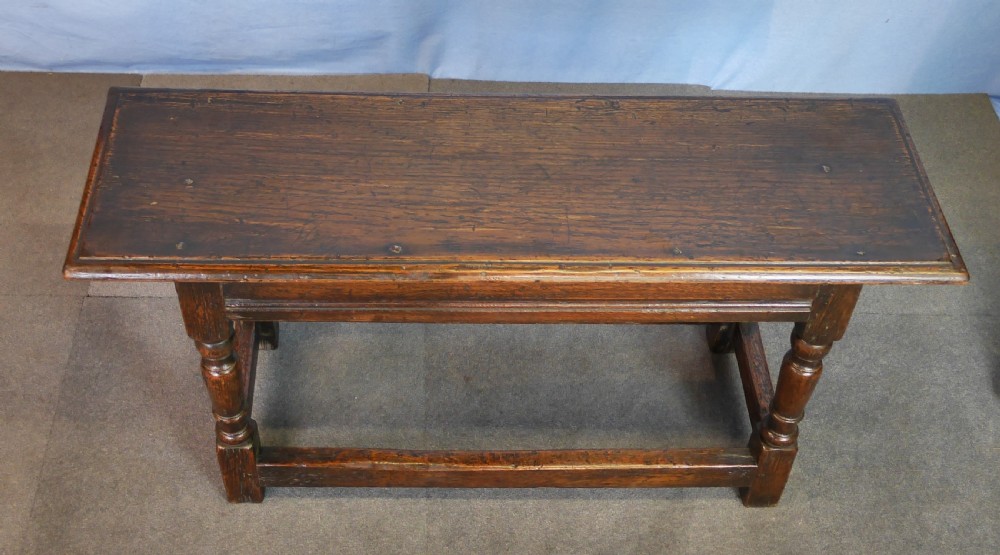 A low rectangular dark oak coffee table featuring baluster-turned legs, block feet, and a surrounding low box stretcher. View VIII