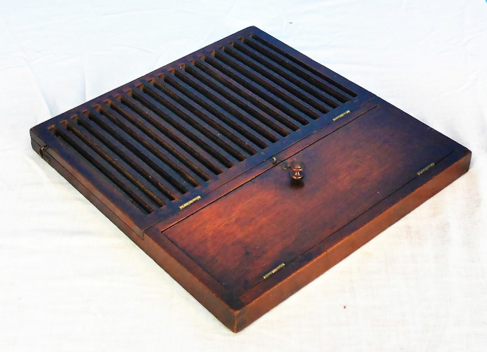 A low-profile Regency mahogany box featuring a slatted upper rack alongside a hinged compartment with a turned wooden knob.