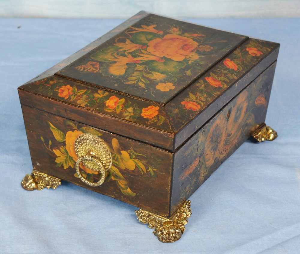 An antique Regency wooden jewellery box with painted floral decorations, gilt ring handles, and ornate brass claw feet. View III