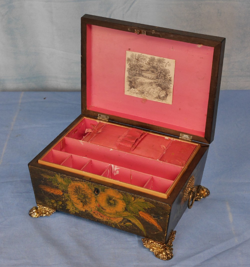 An antique Regency wooden jewellery box with painted floral decorations, gilt ring handles, and ornate brass claw feet. View IV