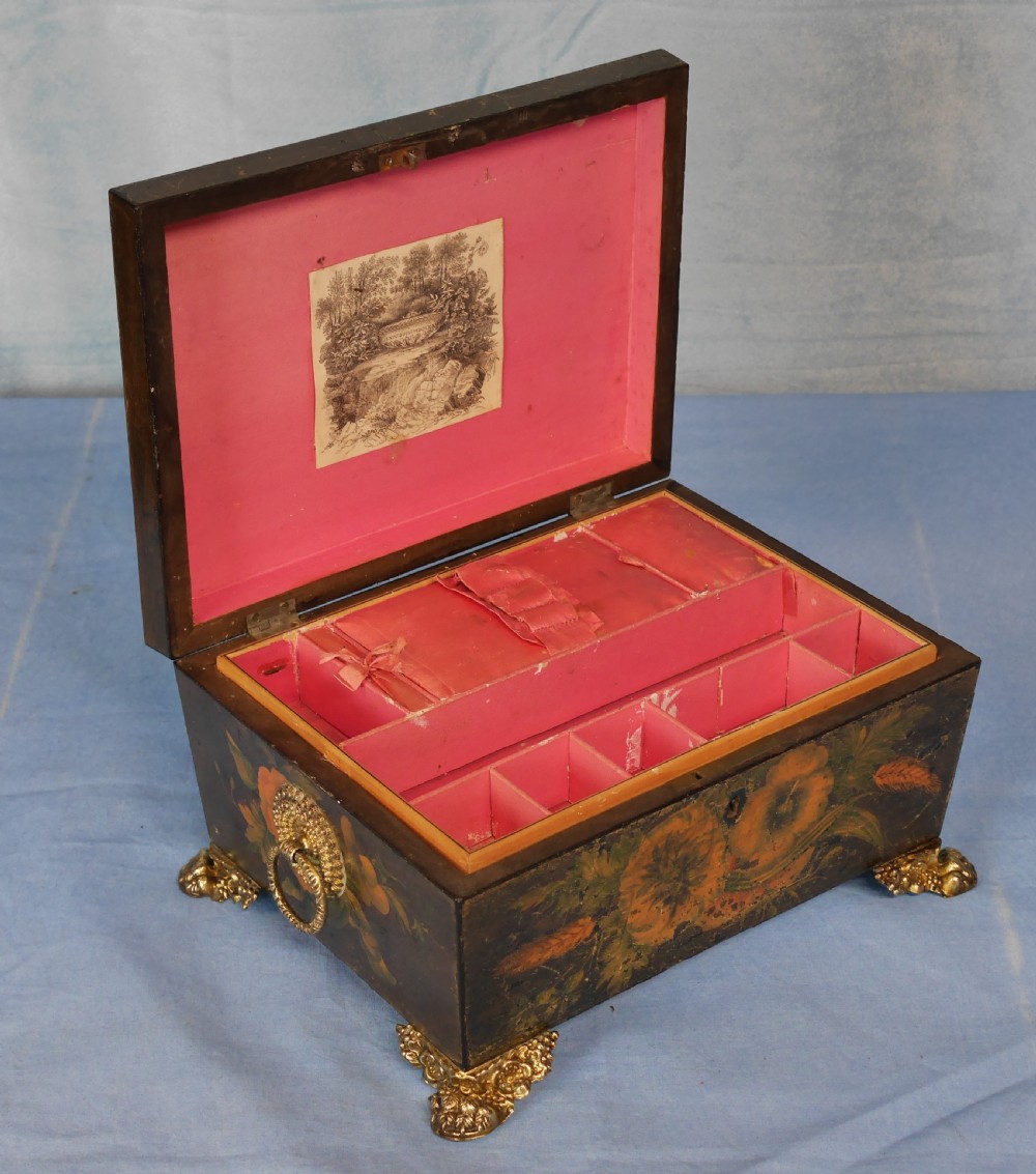 An antique Regency wooden jewellery box with painted floral decorations, gilt ring handles, and ornate brass claw feet. View V