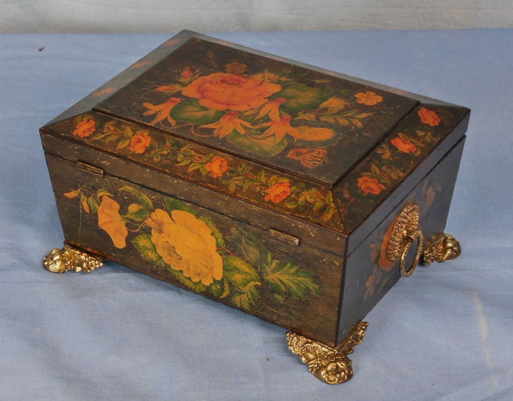 An antique Regency wooden jewellery box with painted floral decorations, gilt ring handles, and ornate brass claw feet. View X
