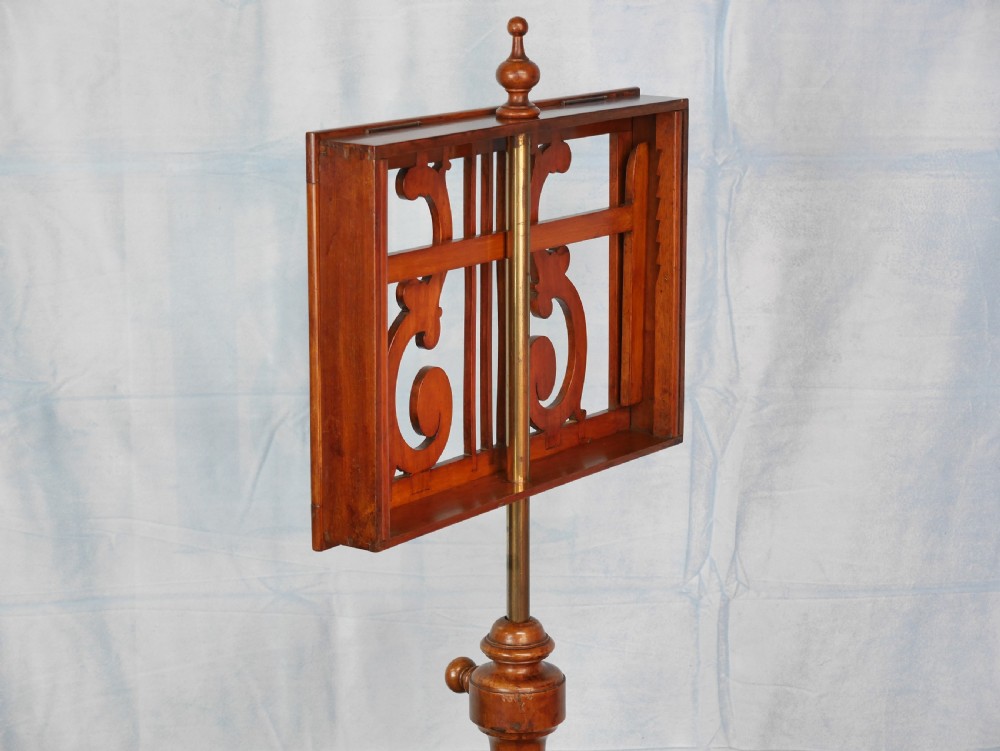 A Victorian mahogany adjustable music stand featuring an openwork lyre-patterned book rest, turned central column, and a tripod base. View VI