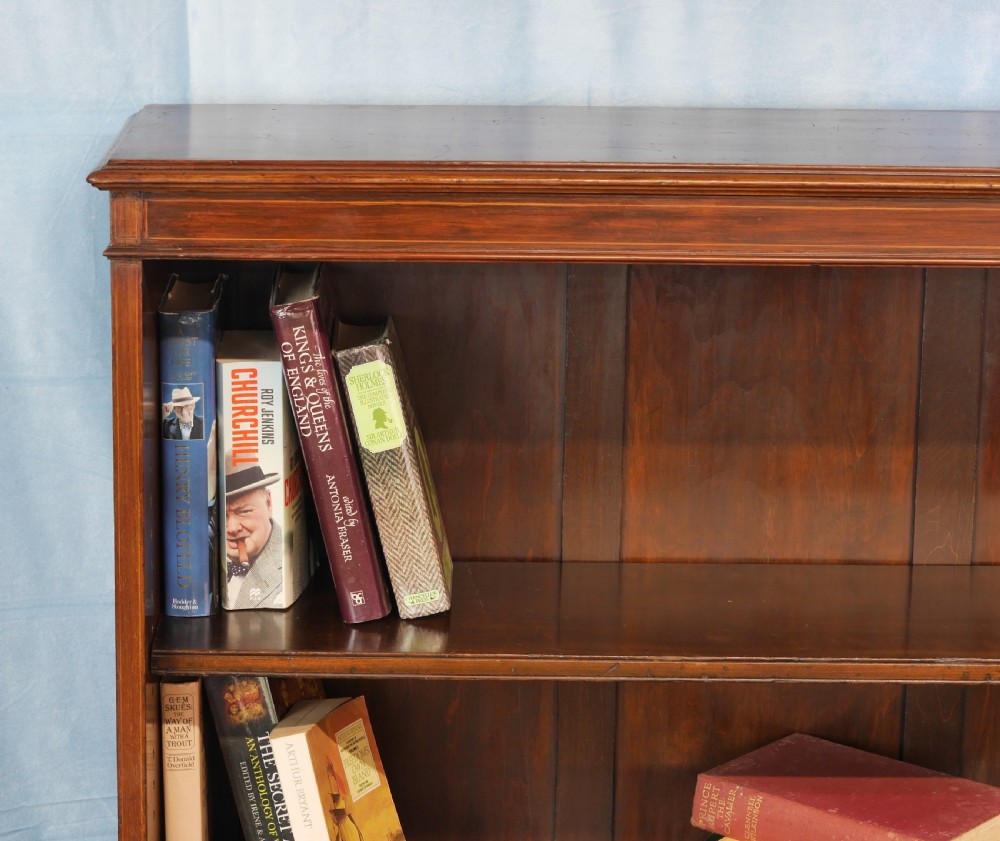 An Edwardian open mahogany bookcase featuring two adjustable shelves, a panelled back, and a solid plinth base. View VI