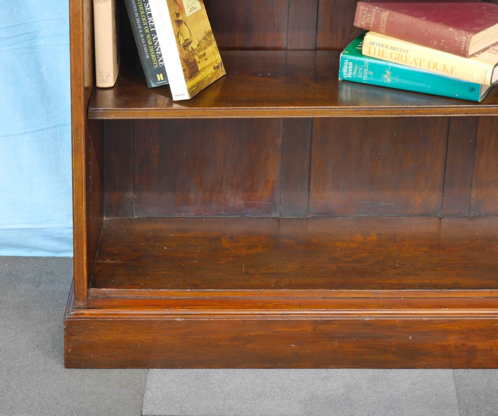 An Edwardian open mahogany bookcase featuring two adjustable shelves, a panelled back, and a solid plinth base. View VII